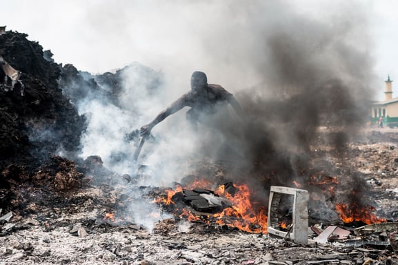 worker burning e-waste